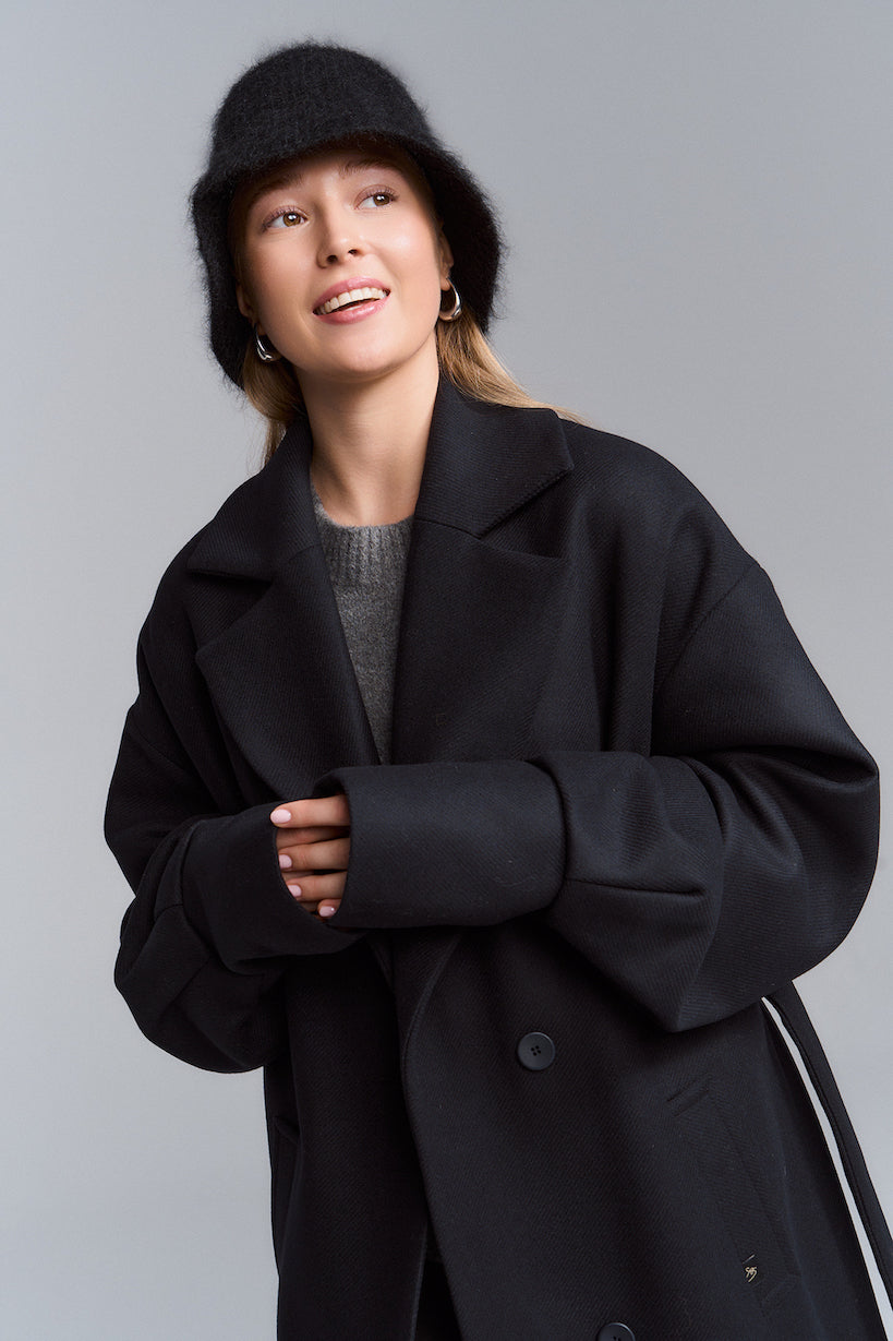 Kołnierz czarnego płaszcza oversize na modelce, portret
