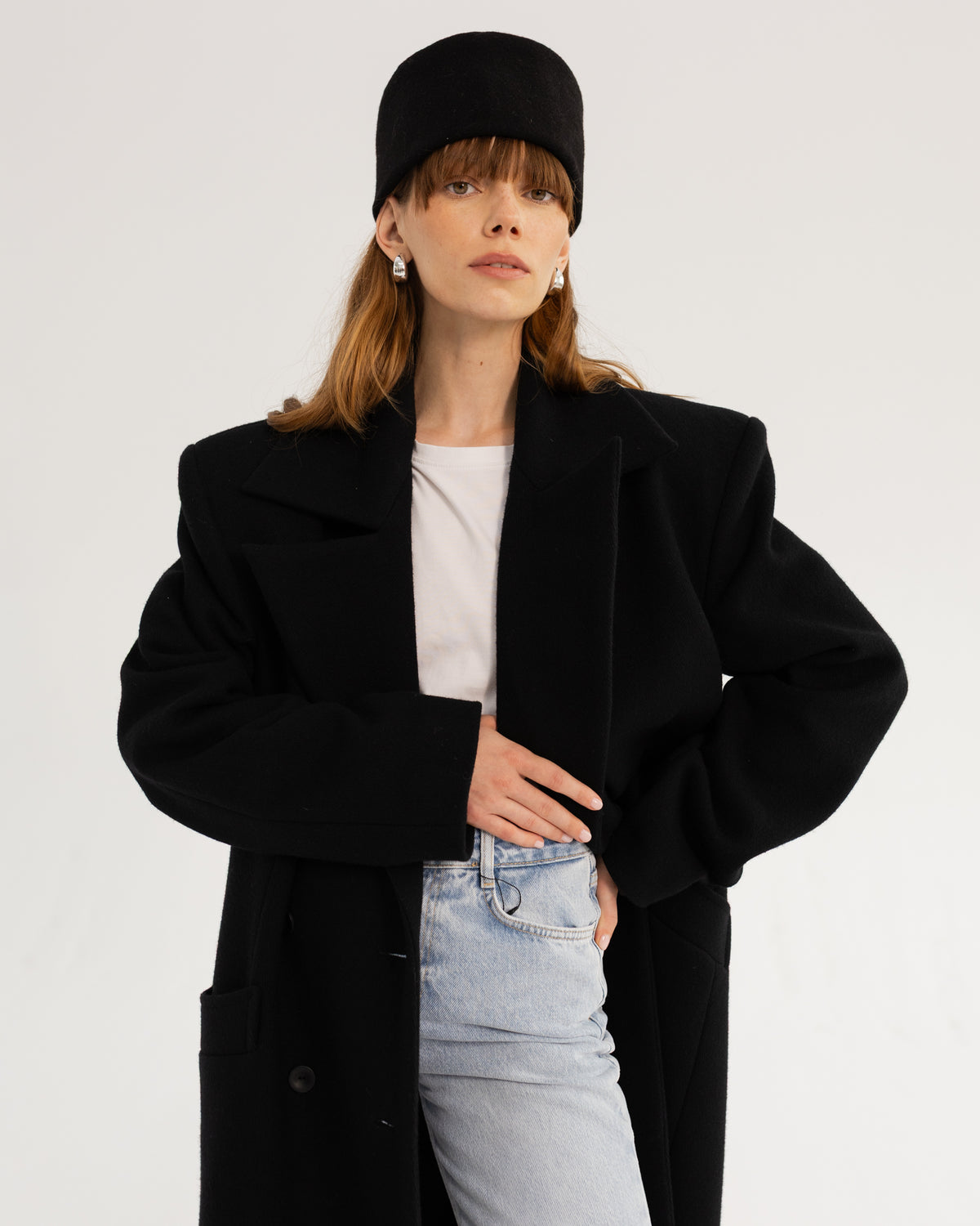 Czarny wełniany płaszcz wide one size na modelce, ujęcie do pasa