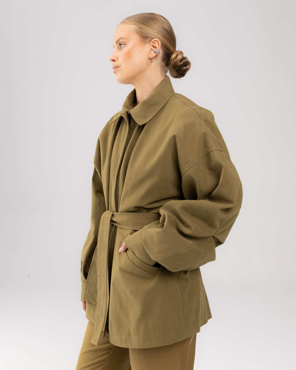 Oliwkowa kurtka oversize heavy zieleń, ręka w kieszeni