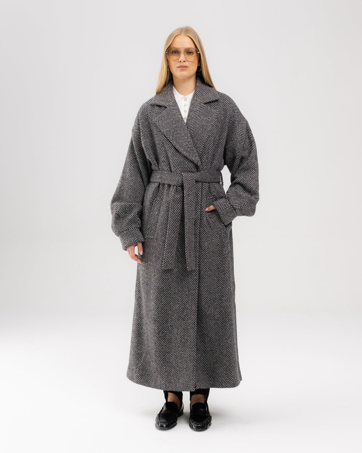 Płaszcz oversize w czarno-białą jodełkę przewiązany paskiem w talii