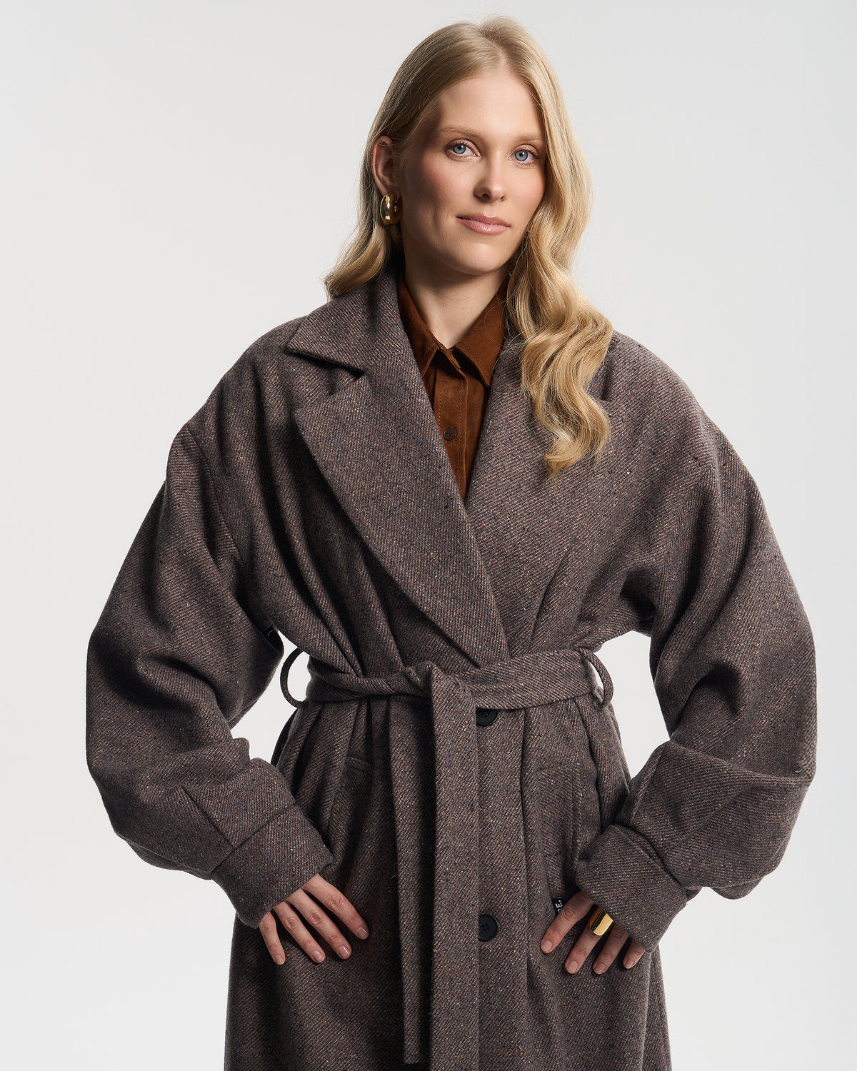 Szarobrązowy płaszcz oversize w paseczki na modelce, ujęcie do uda
