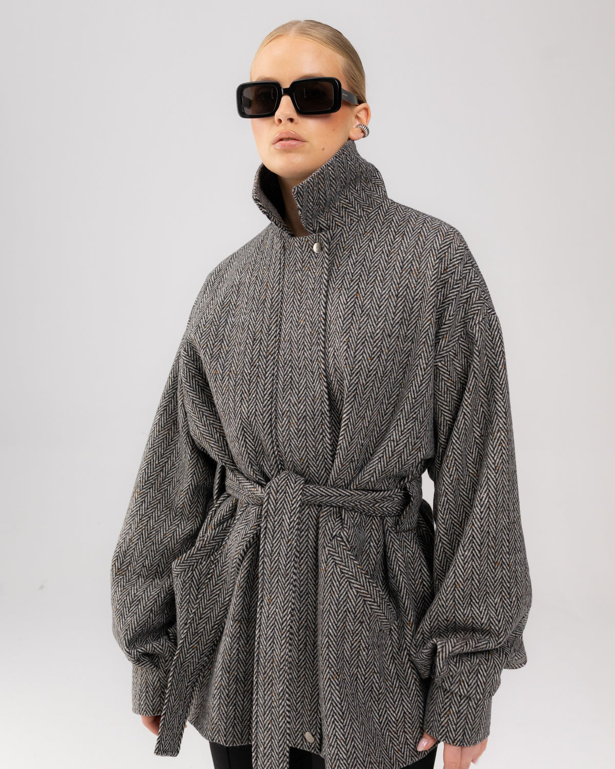 Szary krótki płaszcz city coat w jodełkę na modelce, ujęcie do pasa