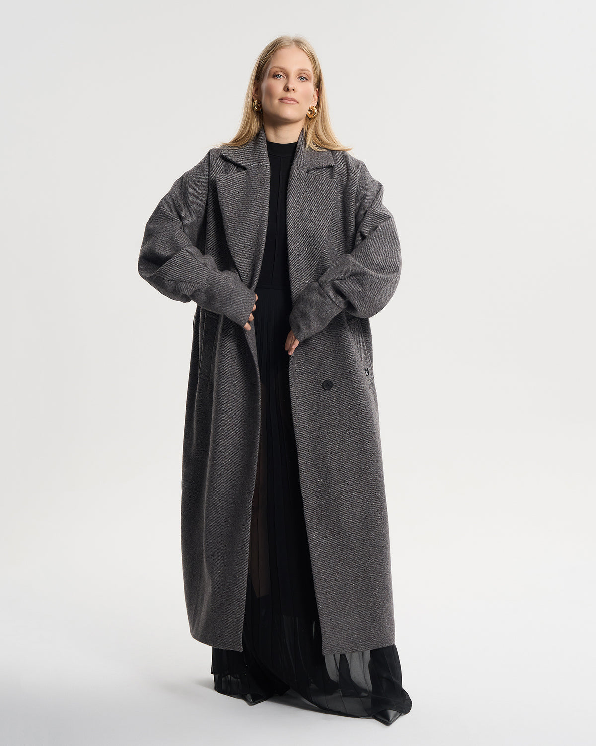 Rozpięty szary płaszcz oversize w paseczki, cała sylwetka