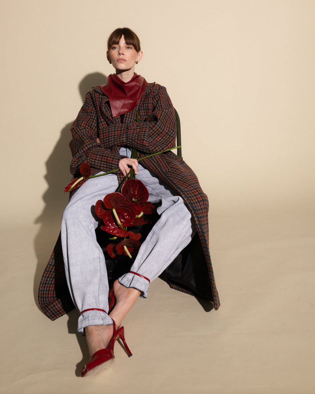Płaszcz oversize w kolorową pepitkę na siedzącej modelce